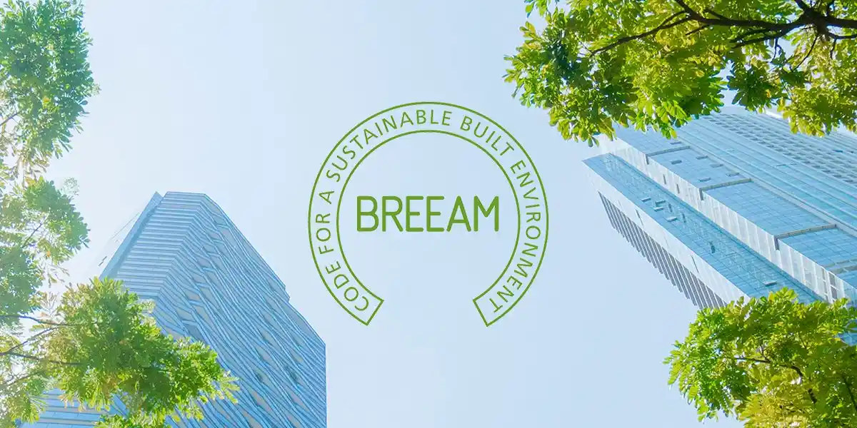 BREEAM logo superimposed on sky background with modern high-rise buildings and green tree foliage